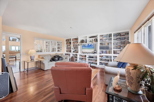 living room featuring dark wood-type flooring and a healthy amount of sunlight