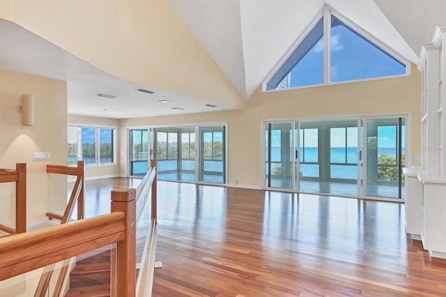 16 Tidy Island Blvd Unit 16, Bradenton, FL 34210 - unfurnished living room with light wood-style floors, baseboards, and high vaulted ceiling