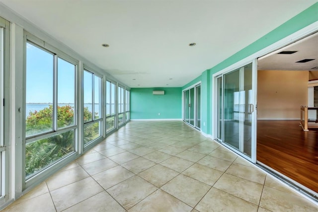 16 Tidy Island Blvd Unit 16, Bradenton, FL 34210 - unfurnished sunroom featuring a water view, tile patterned floors, baseboards, and an AC wall unit