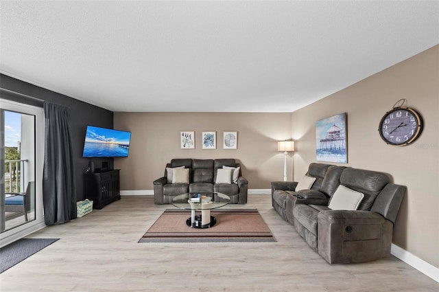 living room featuring a textured ceiling and light wood-type flooring