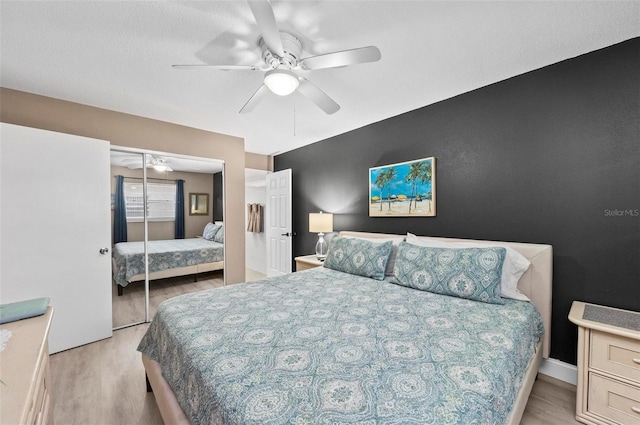 bedroom with ceiling fan, light wood-type flooring, and a closet