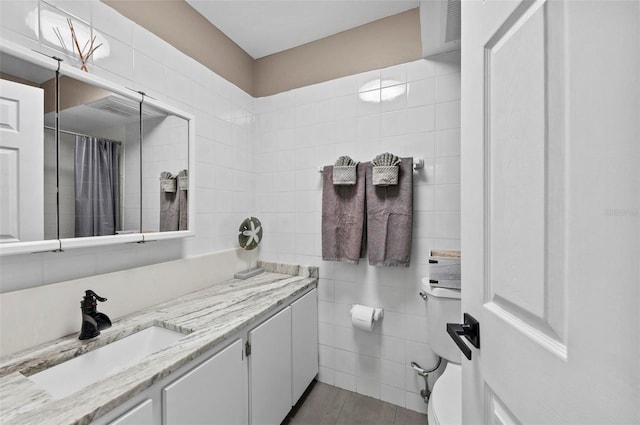 bathroom with vanity, tile walls, and walk in shower