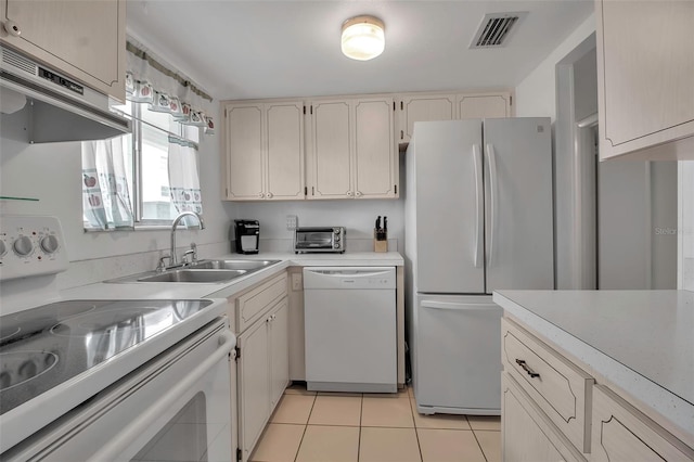 kitchen with sink, light tile patterned floors, extractor fan, and white appliances