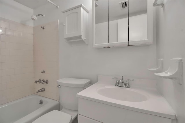 full bathroom featuring vanity, tiled shower / bath combo, and toilet