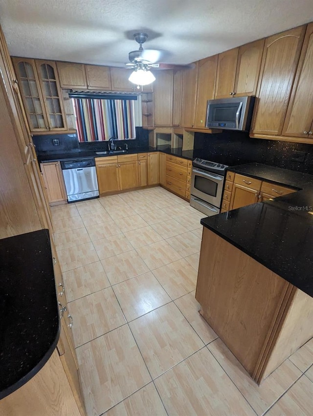 kitchen with ceiling fan, sink, a textured ceiling, light tile patterned floors, and appliances with stainless steel finishes