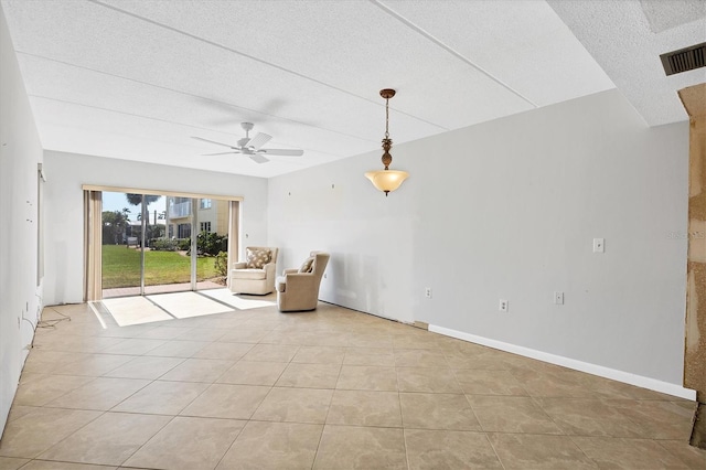 unfurnished room with light tile patterned floors, a textured ceiling, and ceiling fan