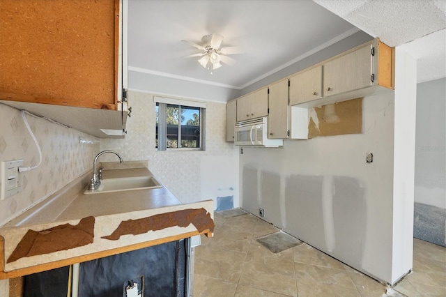 kitchen featuring crown molding, sink, light tile patterned floors, and ceiling fan