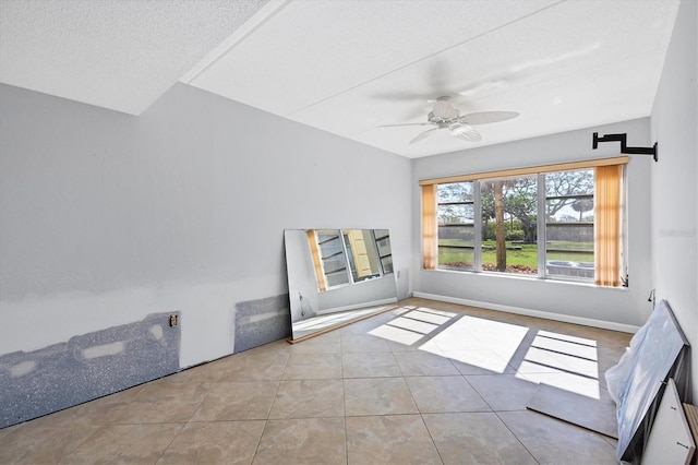 spare room featuring light tile patterned floors, a textured ceiling, and ceiling fan