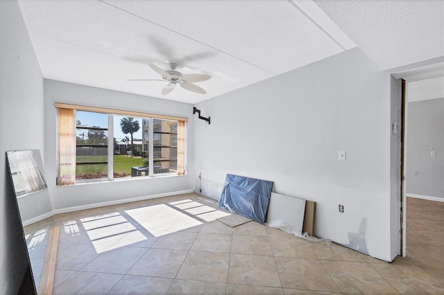 tiled spare room with a textured ceiling and ceiling fan