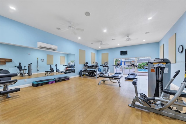 workout area with ceiling fan, wood-type flooring, and a wall mounted AC