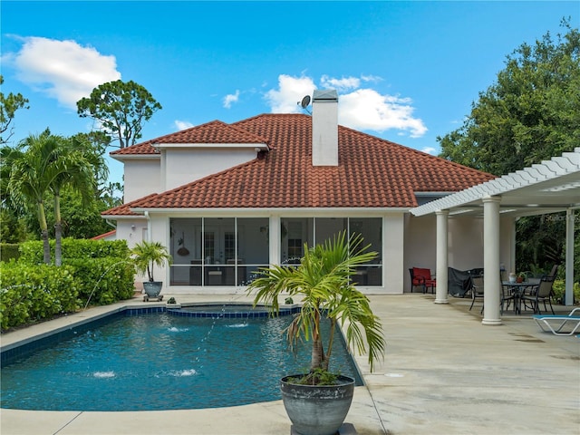 rear view of property featuring a sunroom, pool water feature, and a patio