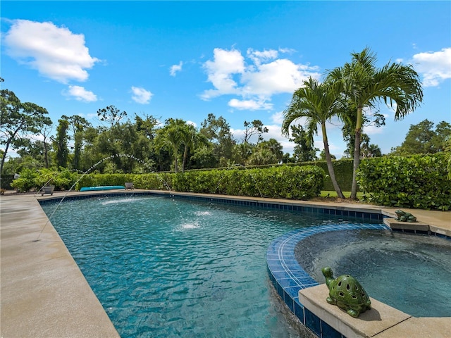 view of pool featuring pool water feature and a hot tub