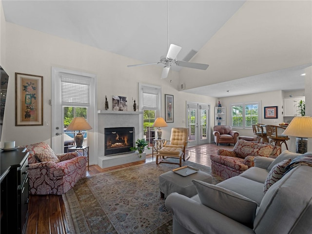 living room with hardwood / wood-style floors, ceiling fan, vaulted ceiling, and french doors