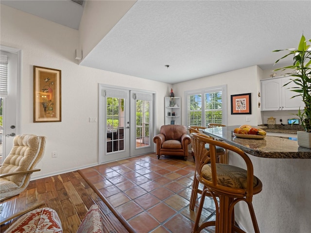 dining space featuring french doors, a textured ceiling, and dark wood-type flooring