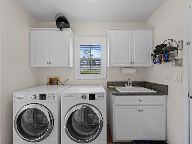 washroom with cabinets, washing machine and dryer, and sink