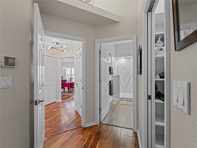 hall featuring a notable chandelier and light wood-type flooring