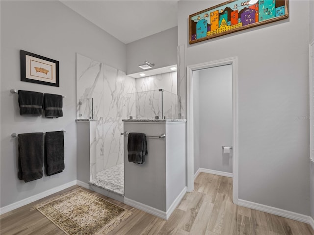 bathroom with hardwood / wood-style floors and tiled shower