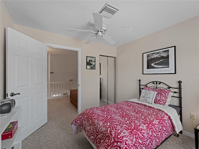 bedroom with carpet, ceiling fan, a textured ceiling, and a closet