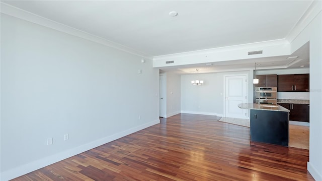 unfurnished living room with crown molding, dark hardwood / wood-style floors, sink, and an inviting chandelier