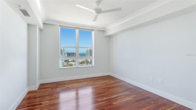 spare room with dark hardwood / wood-style flooring, ornamental molding, and ceiling fan