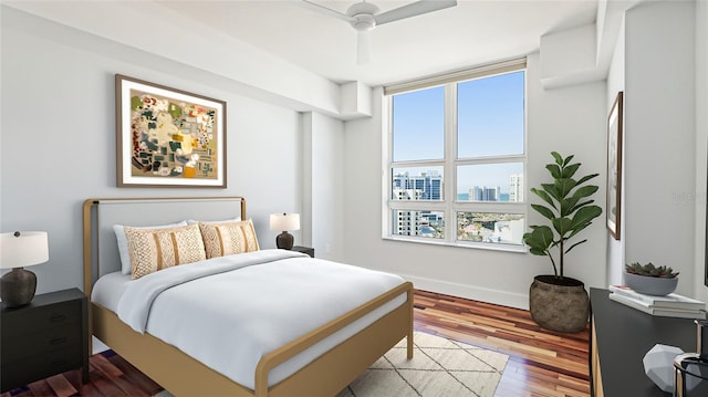 bedroom featuring ceiling fan, multiple windows, and light hardwood / wood-style flooring