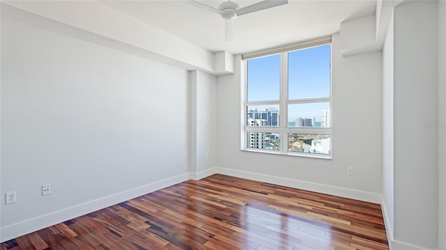 unfurnished room with dark hardwood / wood-style flooring and ceiling fan