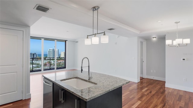 kitchen with an island with sink, sink, and decorative light fixtures