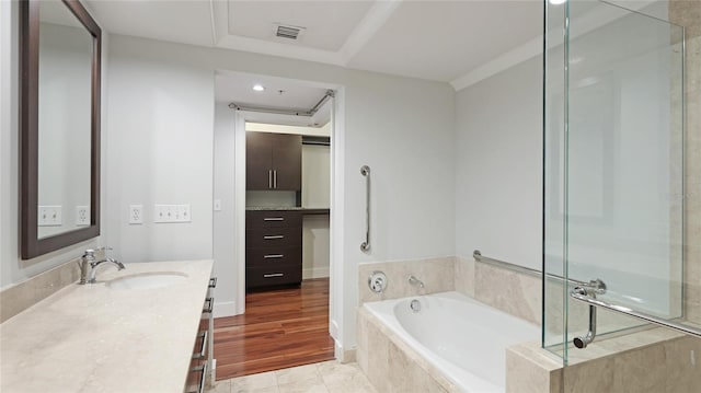 bathroom featuring a relaxing tiled tub, tile patterned floors, and vanity