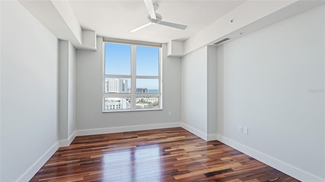 spare room featuring dark wood-type flooring and ceiling fan