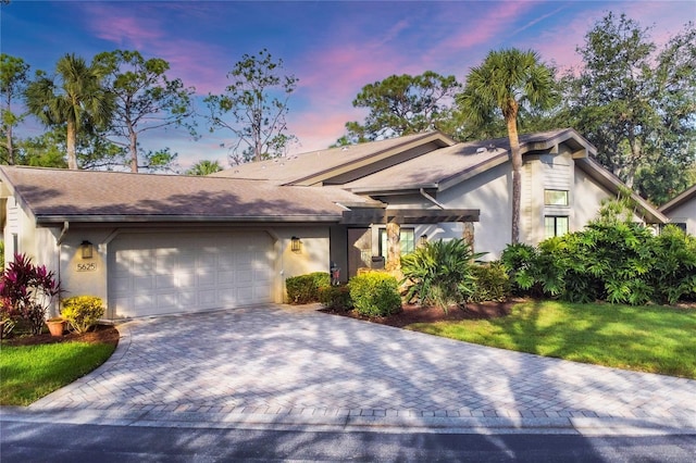 view of front of house with a garage and a lawn