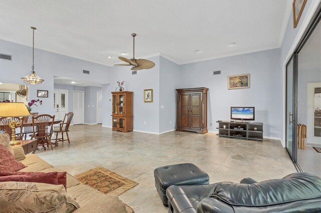 living room with ornamental molding, ceiling fan, and a high ceiling