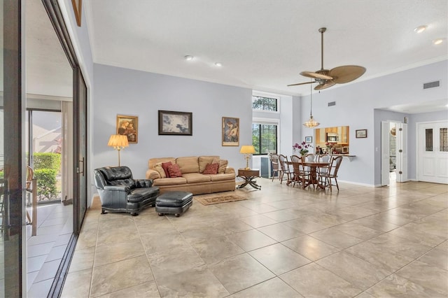 tiled living room featuring ornamental molding and ceiling fan