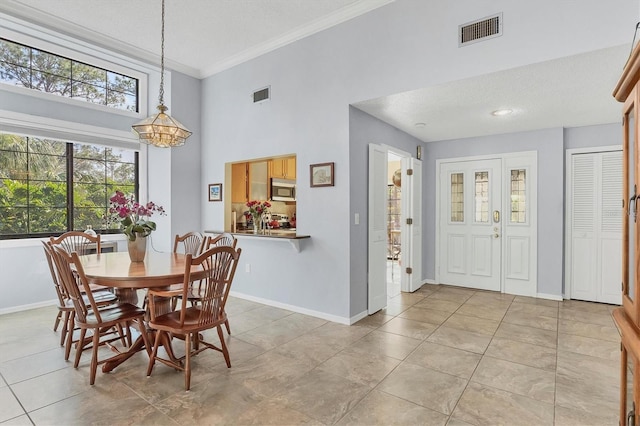 dining space featuring crown molding, a textured ceiling, a healthy amount of sunlight, and light tile patterned flooring