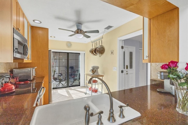 kitchen featuring ceiling fan, sink, decorative backsplash, and electric range oven