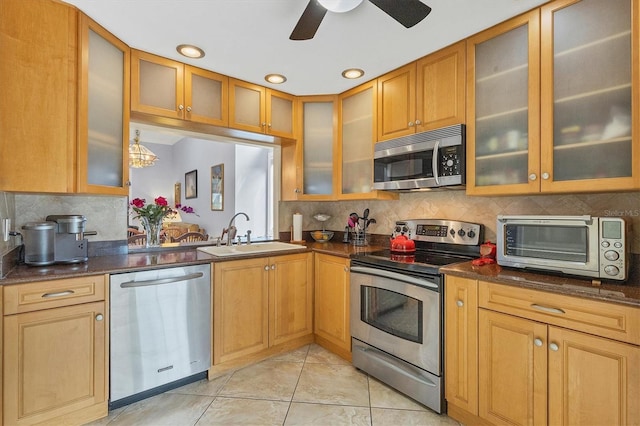 kitchen featuring light tile patterned flooring, tasteful backsplash, sink, dark stone counters, and stainless steel appliances