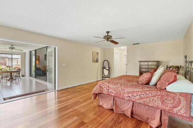 bedroom with ceiling fan, access to exterior, a textured ceiling, and light wood-type flooring