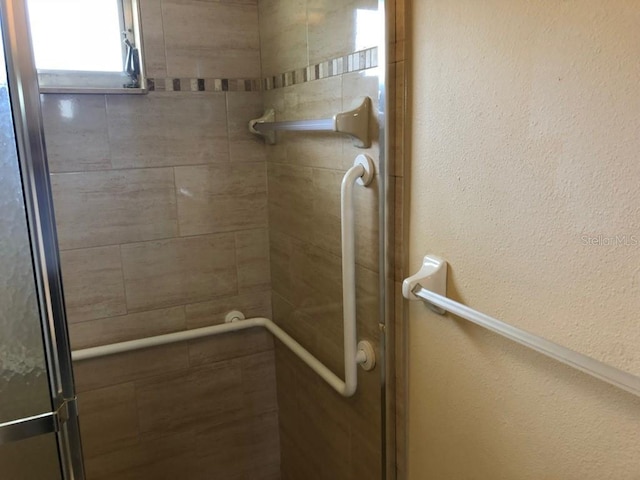 bathroom featuring a shower with door