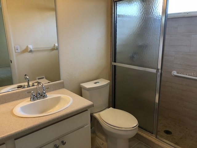 bathroom featuring walk in shower, tile patterned flooring, vanity, and toilet