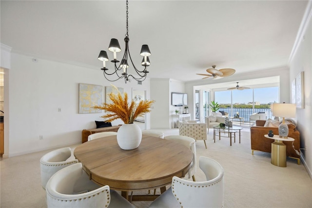 carpeted dining area featuring ceiling fan with notable chandelier and ornamental molding