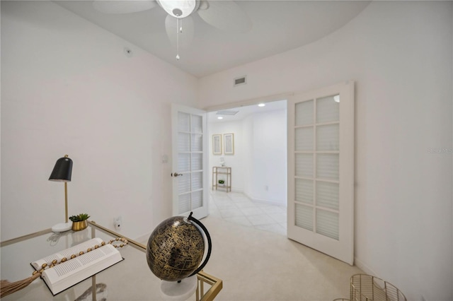 interior space with ceiling fan, light colored carpet, and french doors