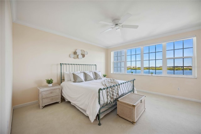 carpeted bedroom with ceiling fan, crown molding, and a water view