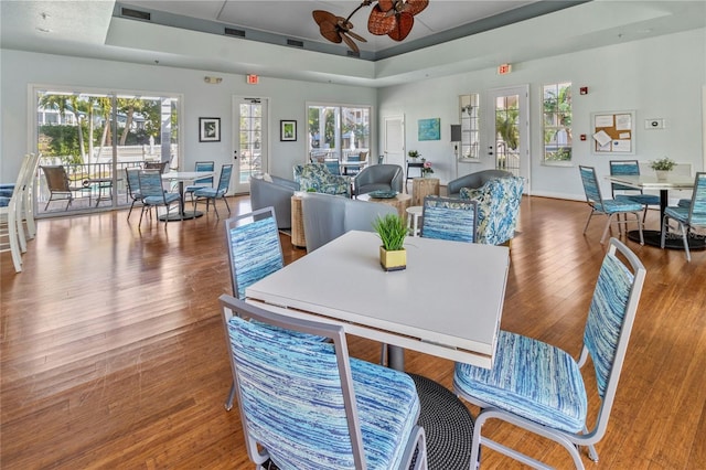 dining space with a tray ceiling, a wealth of natural light, and ceiling fan