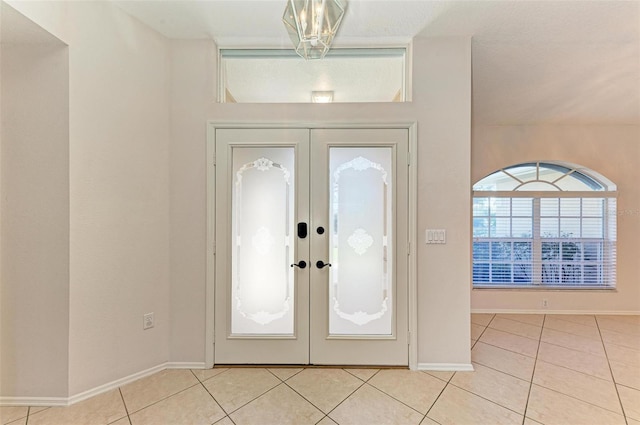 foyer featuring light tile patterned floors and french doors