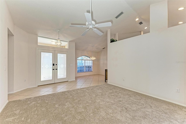 entrance foyer with ceiling fan, french doors, light tile patterned flooring, and vaulted ceiling