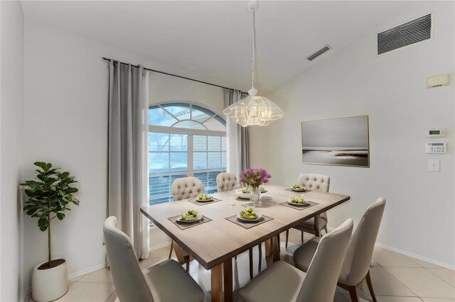 tiled dining space featuring lofted ceiling