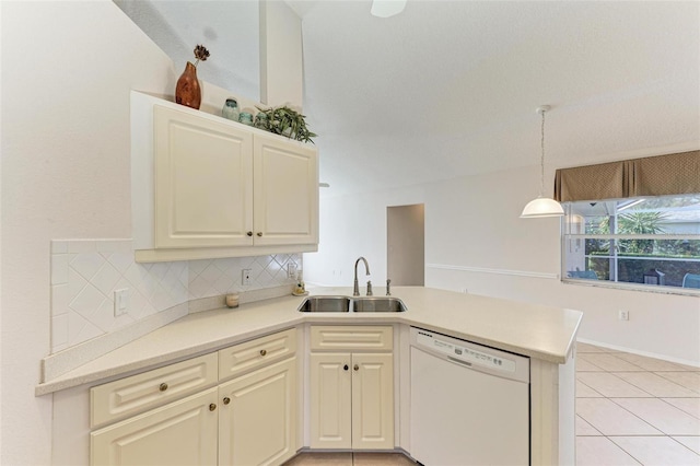 kitchen with kitchen peninsula, backsplash, white dishwasher, sink, and hanging light fixtures