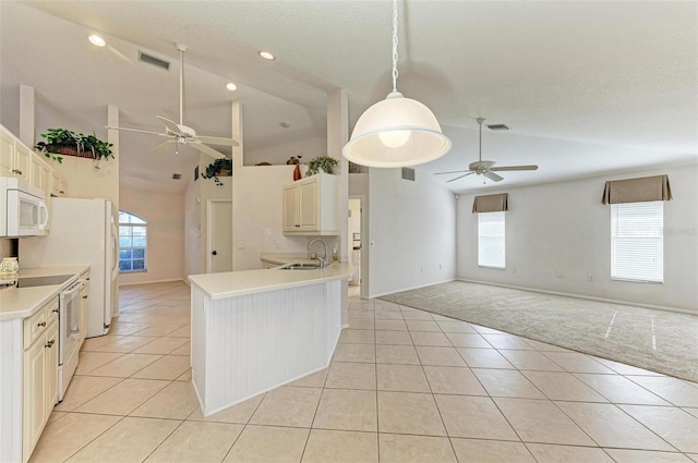 kitchen with white appliances, sink, hanging light fixtures, vaulted ceiling, and light tile patterned floors