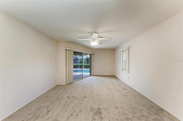 empty room featuring light carpet, a textured ceiling, and ceiling fan