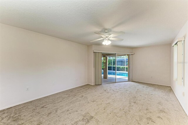 carpeted empty room featuring ceiling fan and a textured ceiling