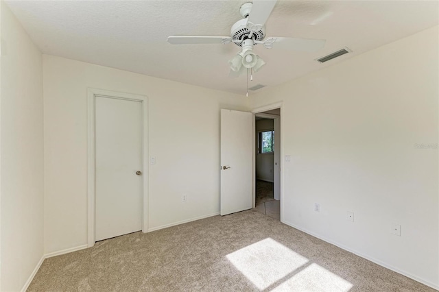 unfurnished bedroom featuring ceiling fan and light carpet